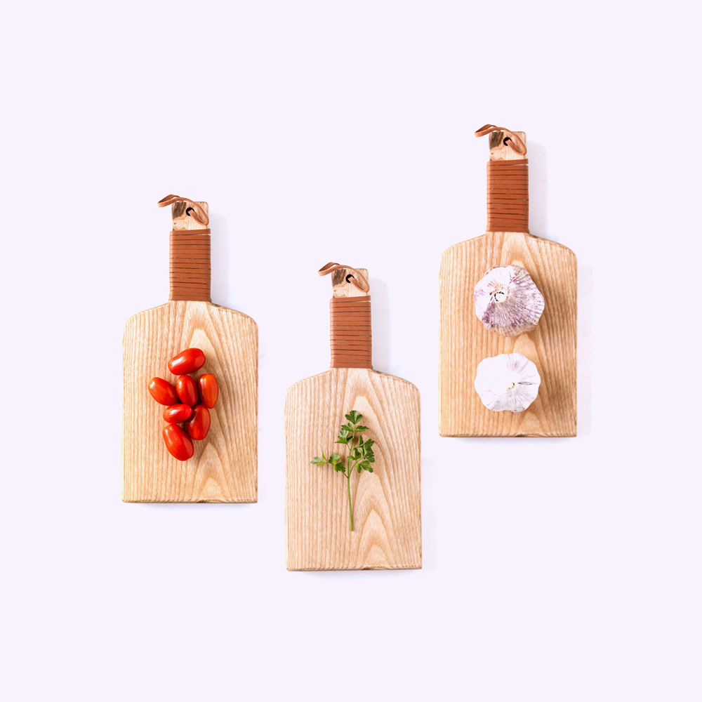 ingredienti su ttre taglieri, aglio, prezzemolo, pomodorini 